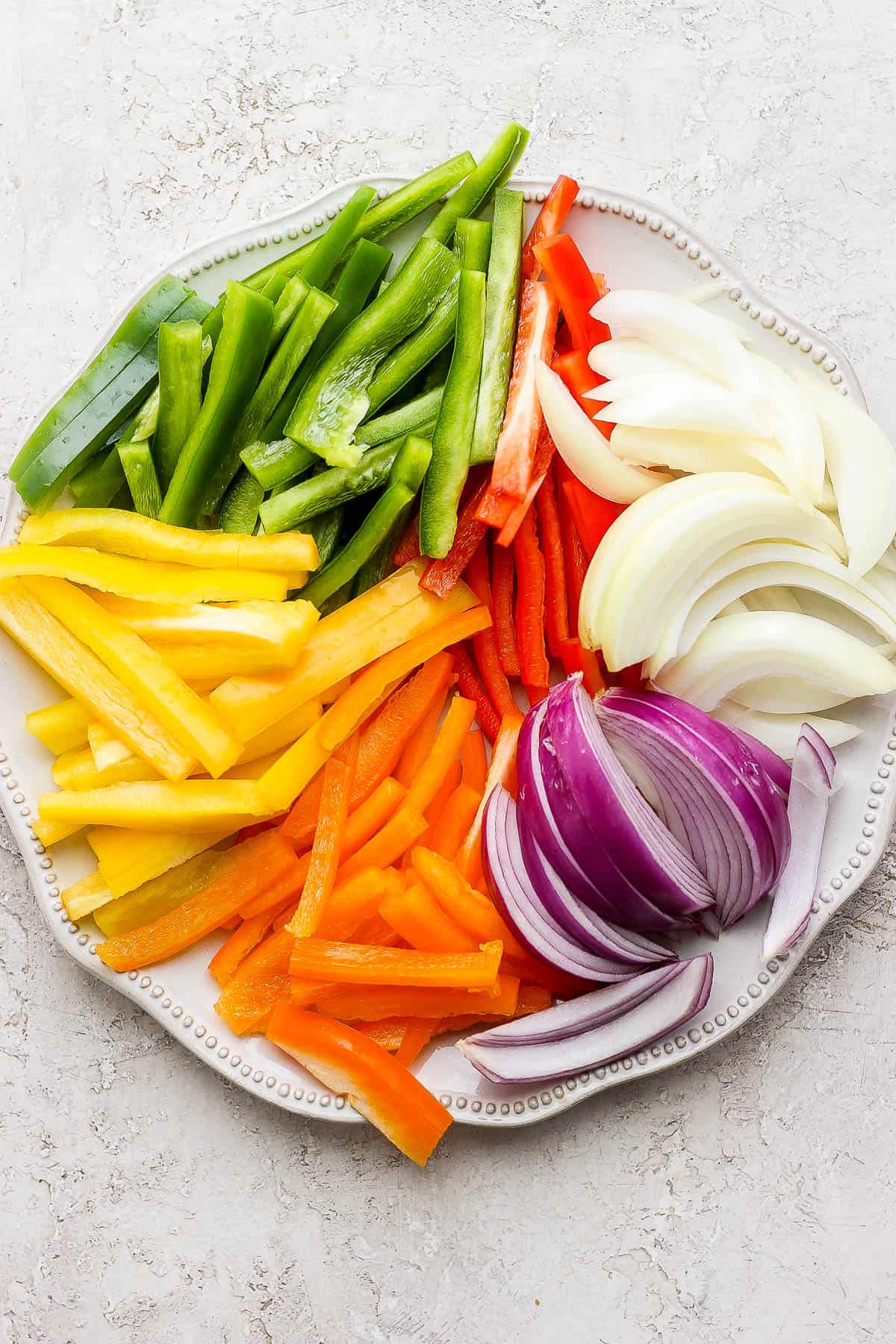 Strips of bell pepper and onion on a large plate.