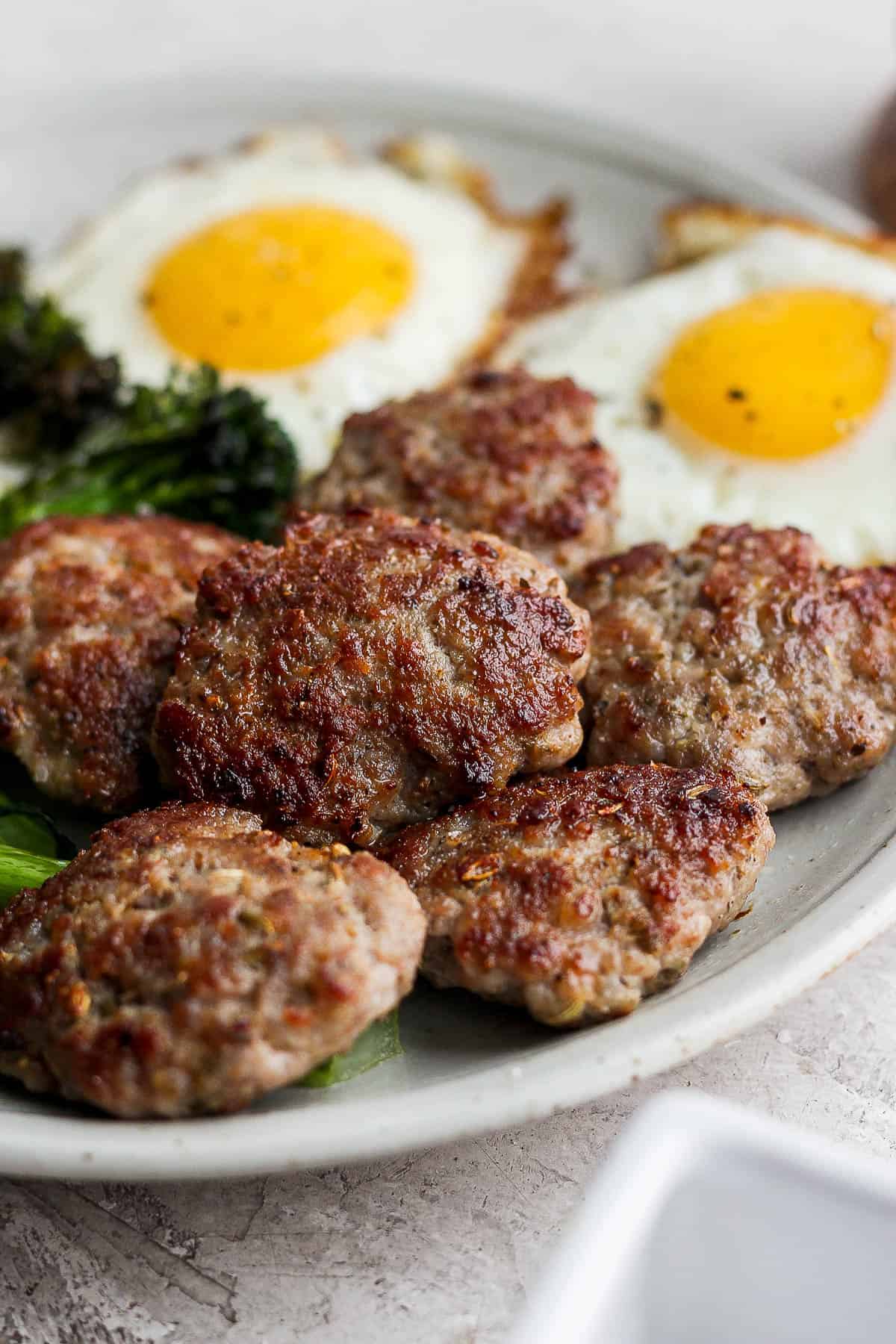 Another view of the sausage on a plate with eggs.
