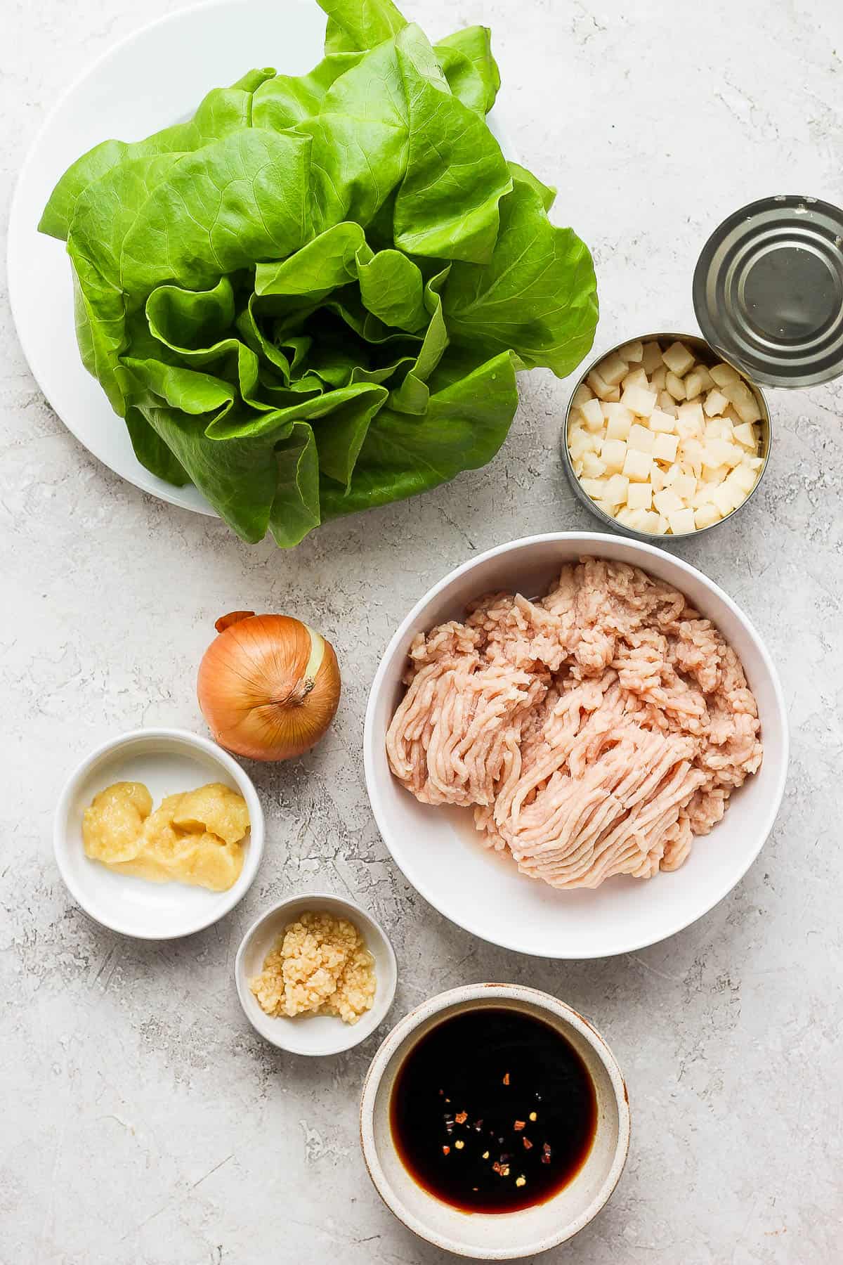 The ingredients for chicken lettuce wraps in separate dishes.