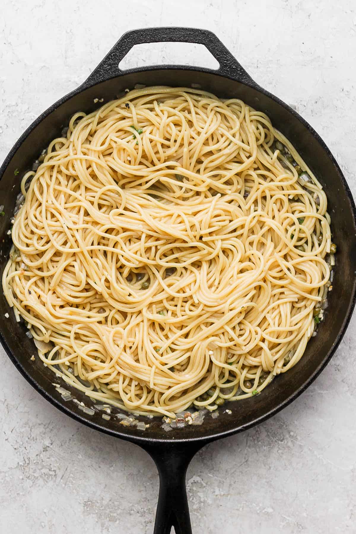 Chicken and lemon slices removed fro the skillet and the cooked noodles have now been added.