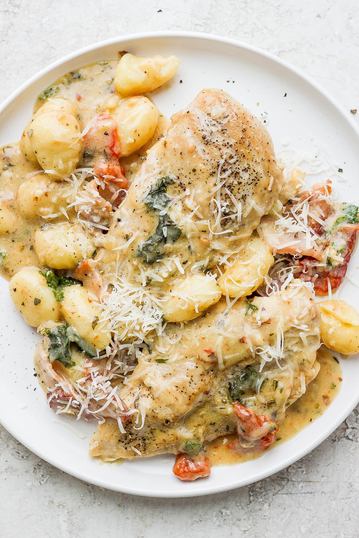 Tuscan chicken on a white plate.