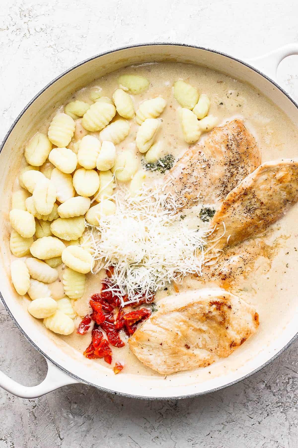 Gnocchi, sun-dried tomatoes, kale, parmesan cheese, Italian seasoning, lemon juice added to the pan and then the chicken added back.