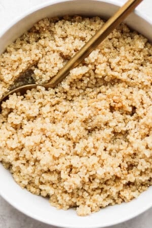 Bowl of coconut quinoa with spoon sticking out.