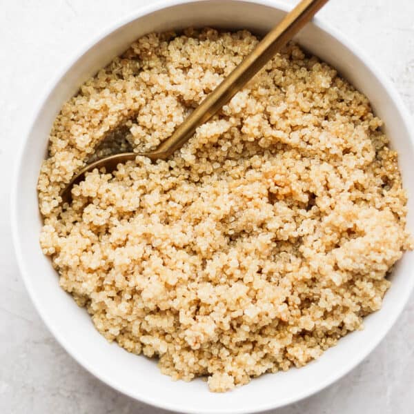Bowl of coconut quinoa with spoon sticking out.