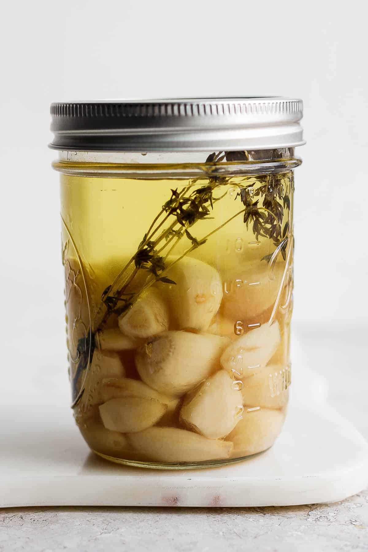 Garlic confit in a mason jar.