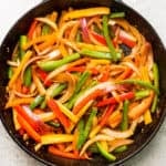 A cast iron skillet filled with fajita veggies.