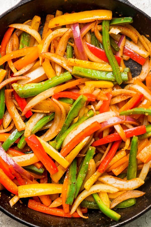 A cast iron skillet filled with fajita veggies.