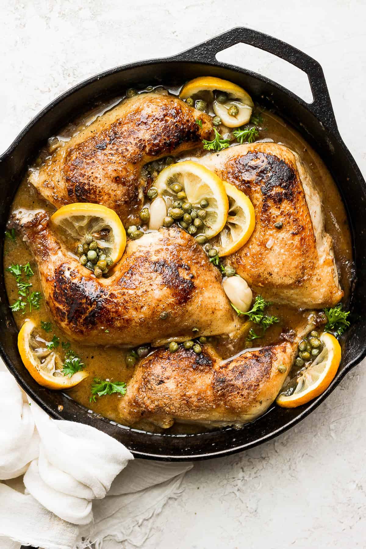 Lemon garlic chicken in the skillet after baking in the oven.