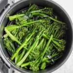 An air fryer filled with broccolini.