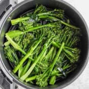 An air fryer filled with broccolini.