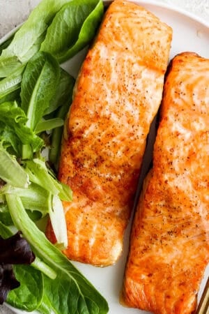 A plate of air fryer salmon with lettuce.
