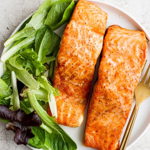 A plate of air fryer salmon with lettuce.