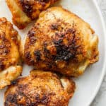 A plate of crispy air fryer chicken thighs on a plate.