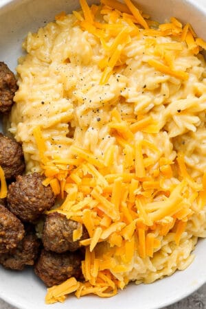 Bowl of cheesy orzo with beef meatballs.