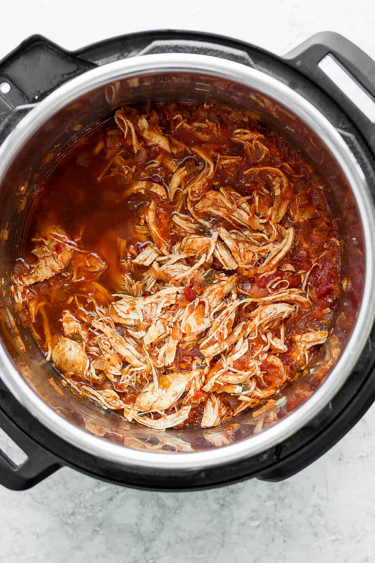 The salsa mixture mixed in with the shredded chicken in the instant pot. 