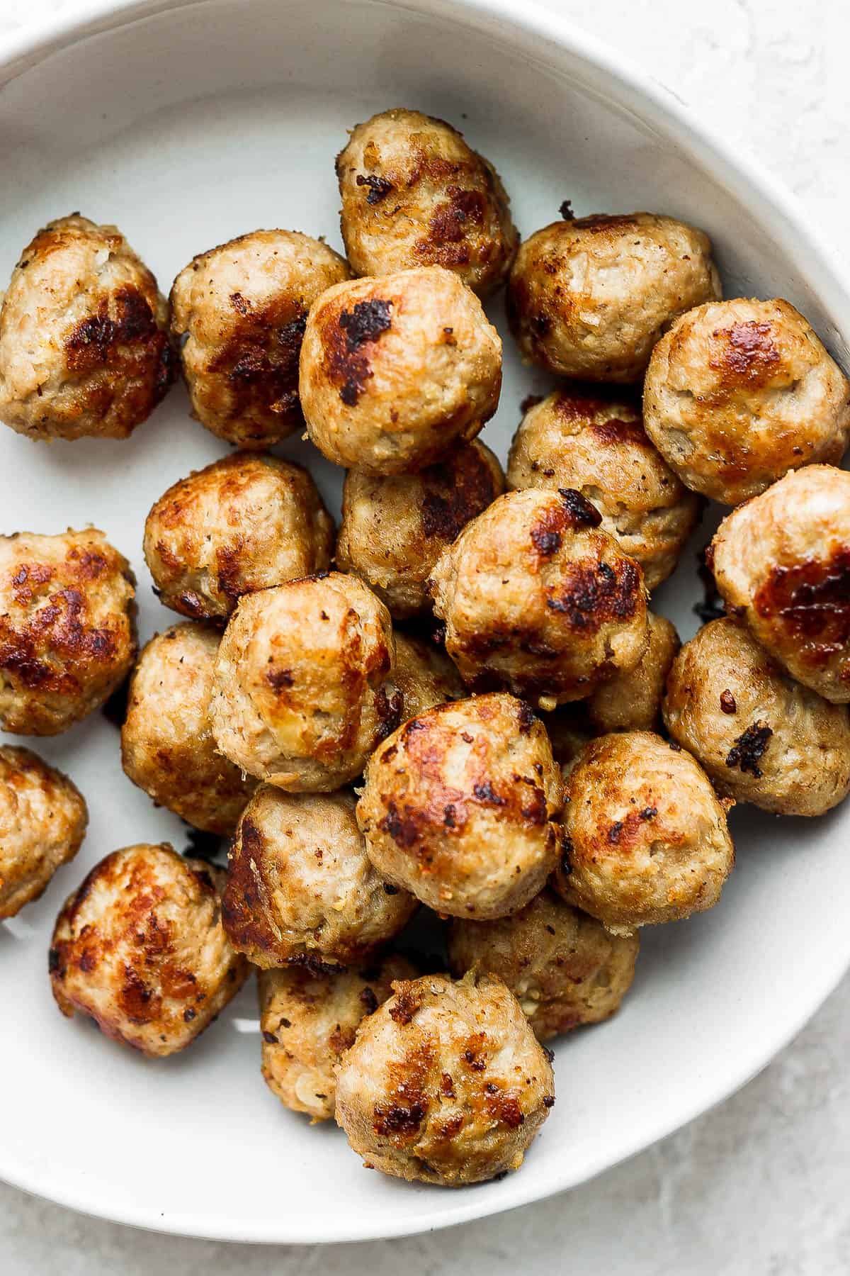 Cooked turkey meatballs in a large white bowl
