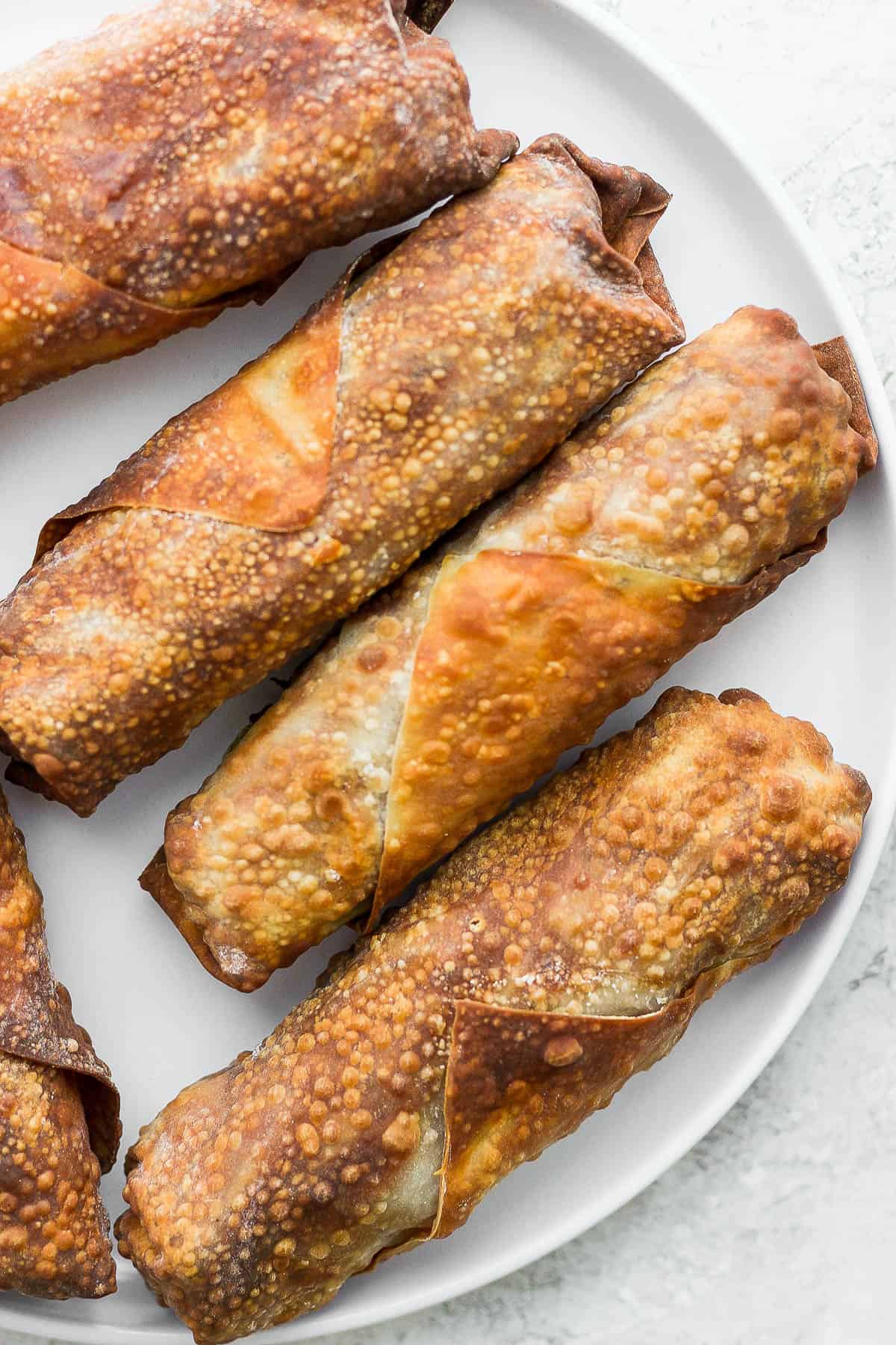 Air fried egg rolls on a white plate.