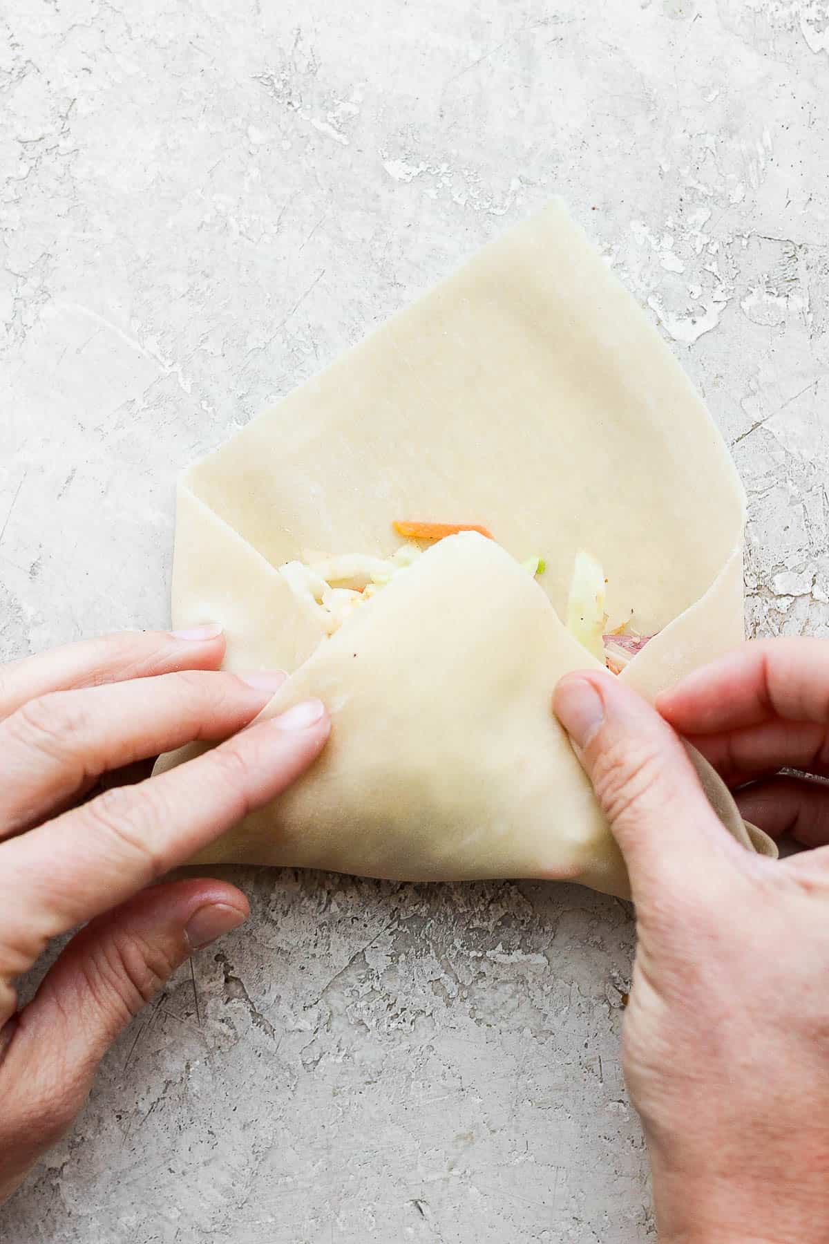 The corn of the egg roll wrapper folded over the filling.
