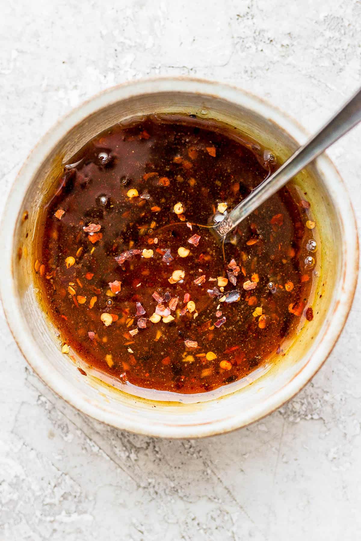 Hot honey sauce in a small bowl with a spoon.