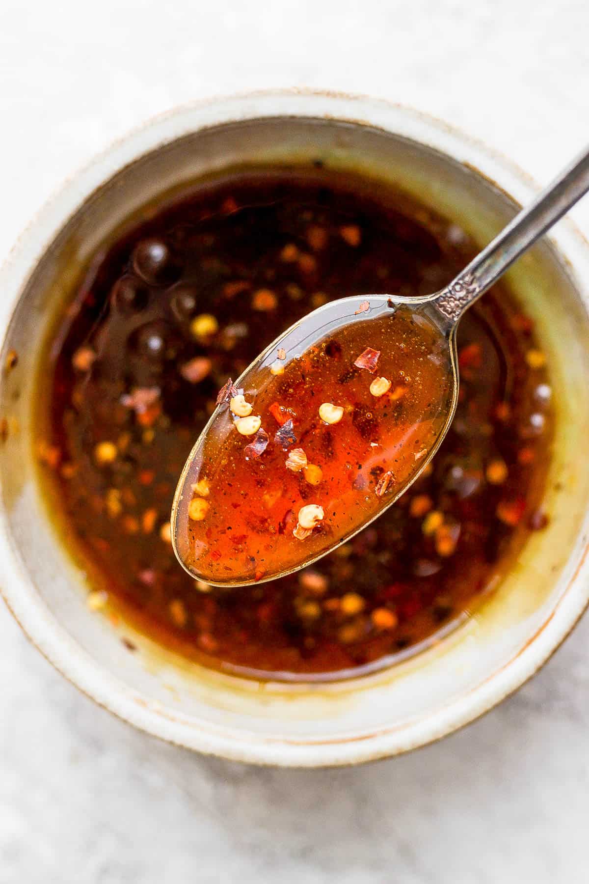 Hot honey sauce in a small bowl with a spoon.