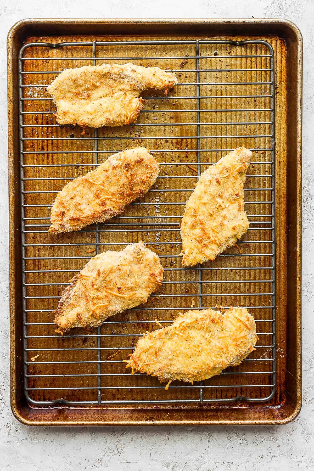 Fully baked chicken cutlets on the wire rack.