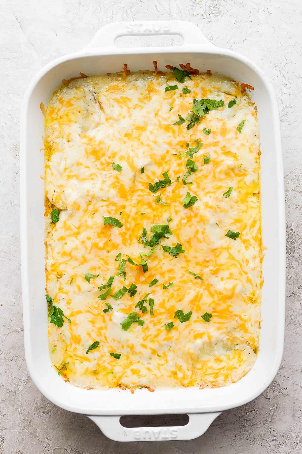 Cheesy scalloped potatoes in the baking dish after being cooked.