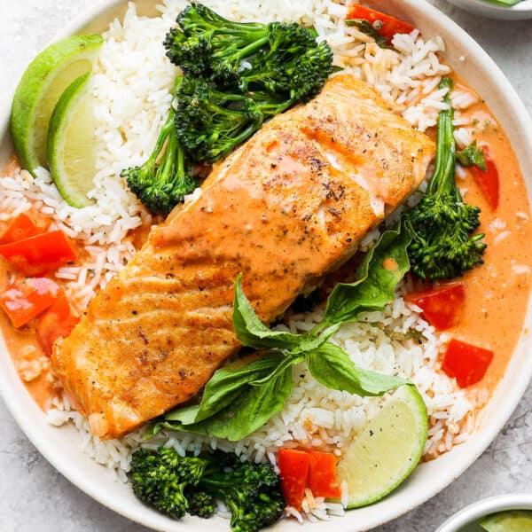 A bowl of rice with broccoli and a piece of coconut curry salmon.
