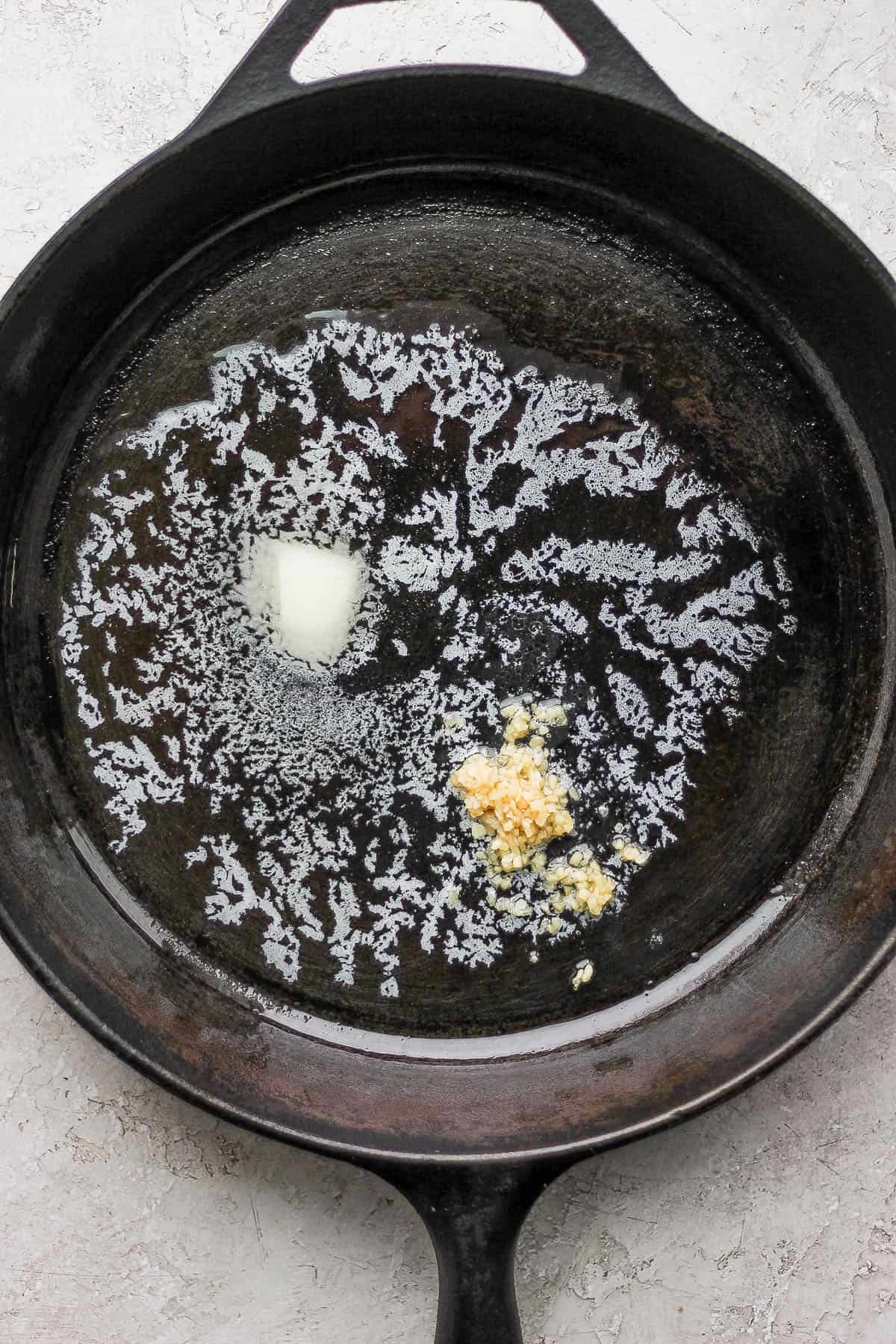 Butter and garlic in a skillet to make homemade corned beef hash.