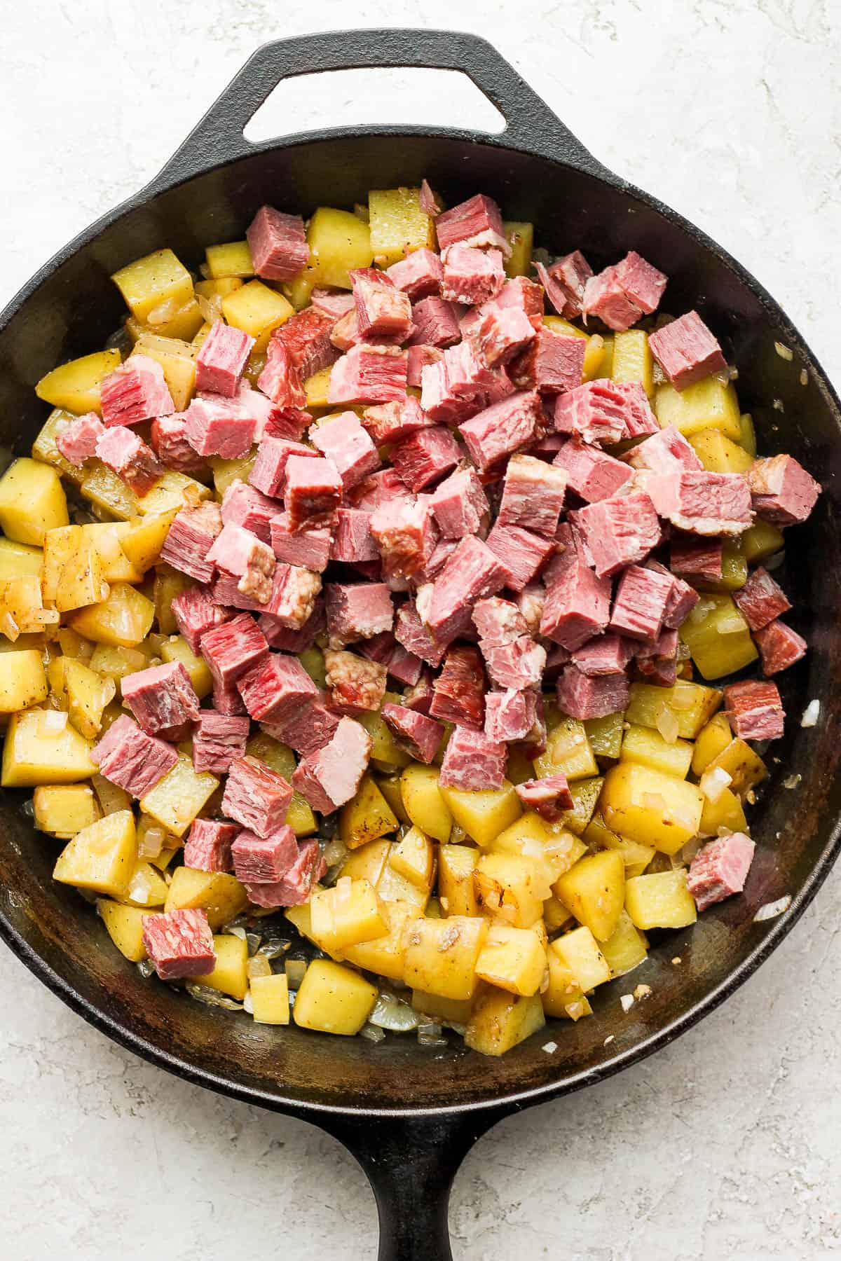 Corned beef added on top of the cubed potatoes.