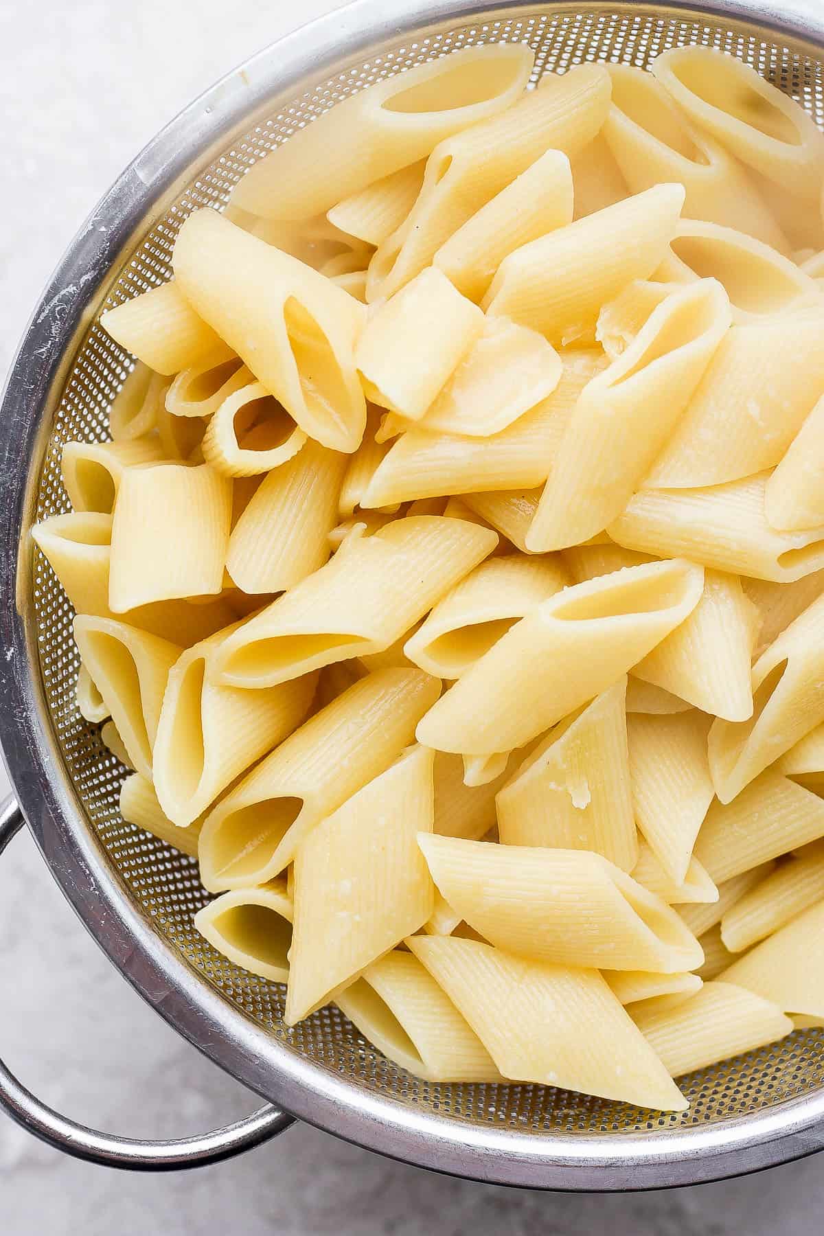 Cooked noodles in a collander.