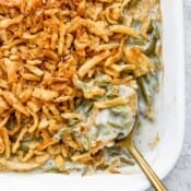 Top shot of the corner of a casserole dish filled with easy green bean casserole and topped with french fried onions.