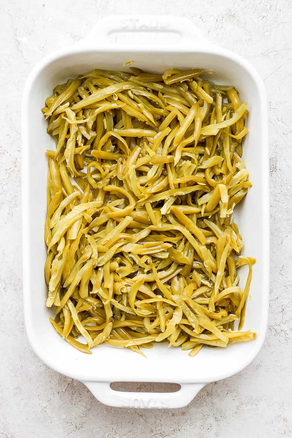 Canned, french-cut style green beans in a baking dish.