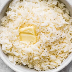 Bowl of garlic butter rice with a small slice of butter on top.