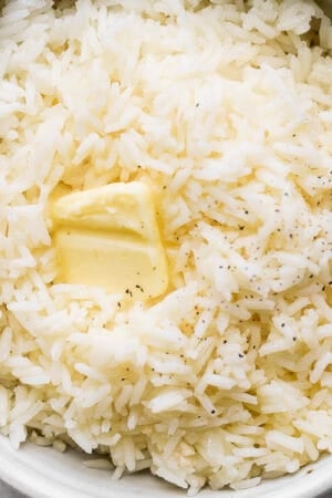 Bowl of garlic butter rice with a small slice of butter on top.