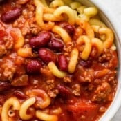 Close up shot of a bowl of goulash with elbow macaroni noodles and kidney beans.