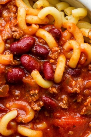 Close up shot of a bowl of goulash with elbow macaroni noodles and kidney beans.
