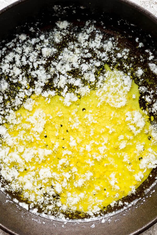 A small cast iron skillet with melted, smoked butter inside.