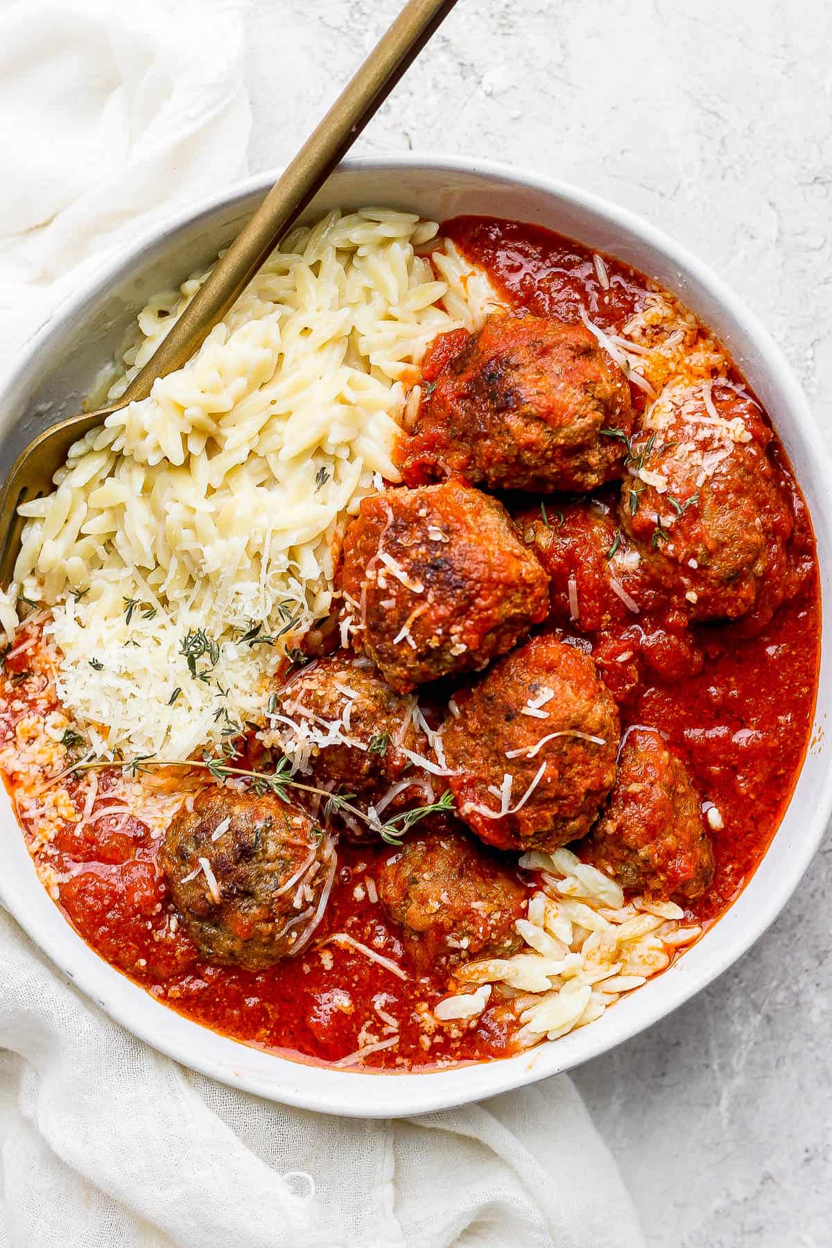 Saucy italian meatballs and parmesan orzo in a bowl.