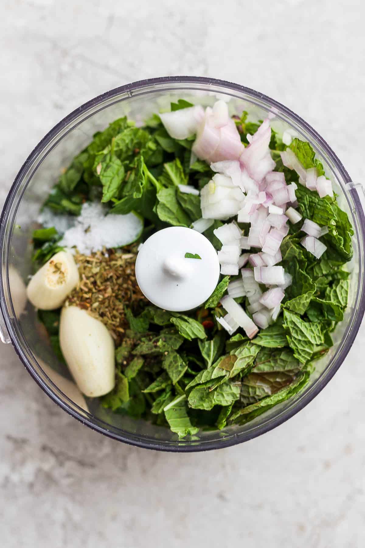 Mint chimichurri ingreidedints in a food processor.