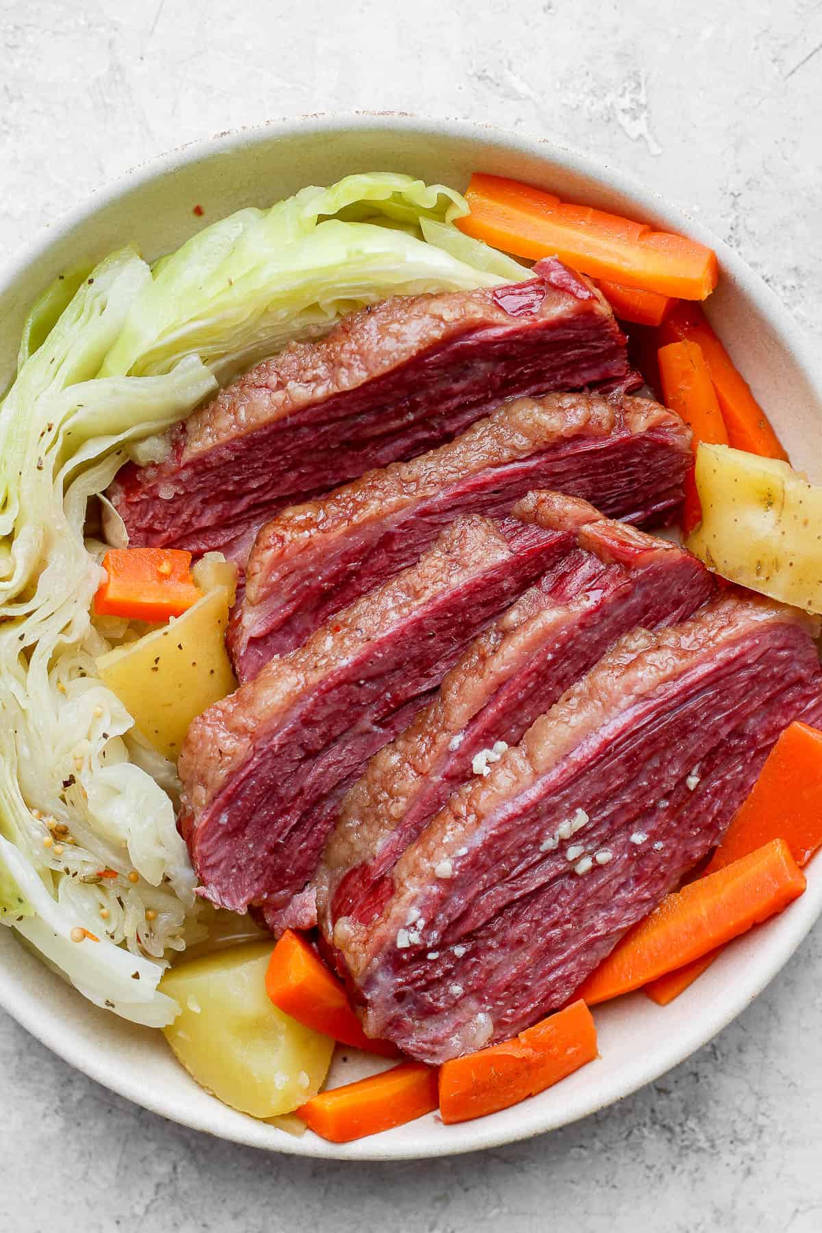 Smoked corned beef and cabbage in a white bowl.