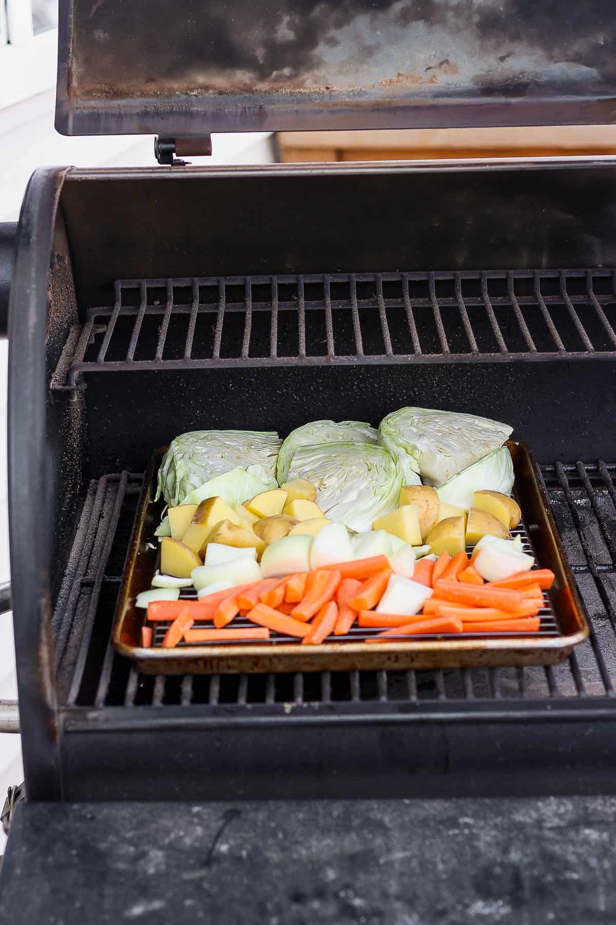 Baking sheet of fresh vegetables on the smoker.