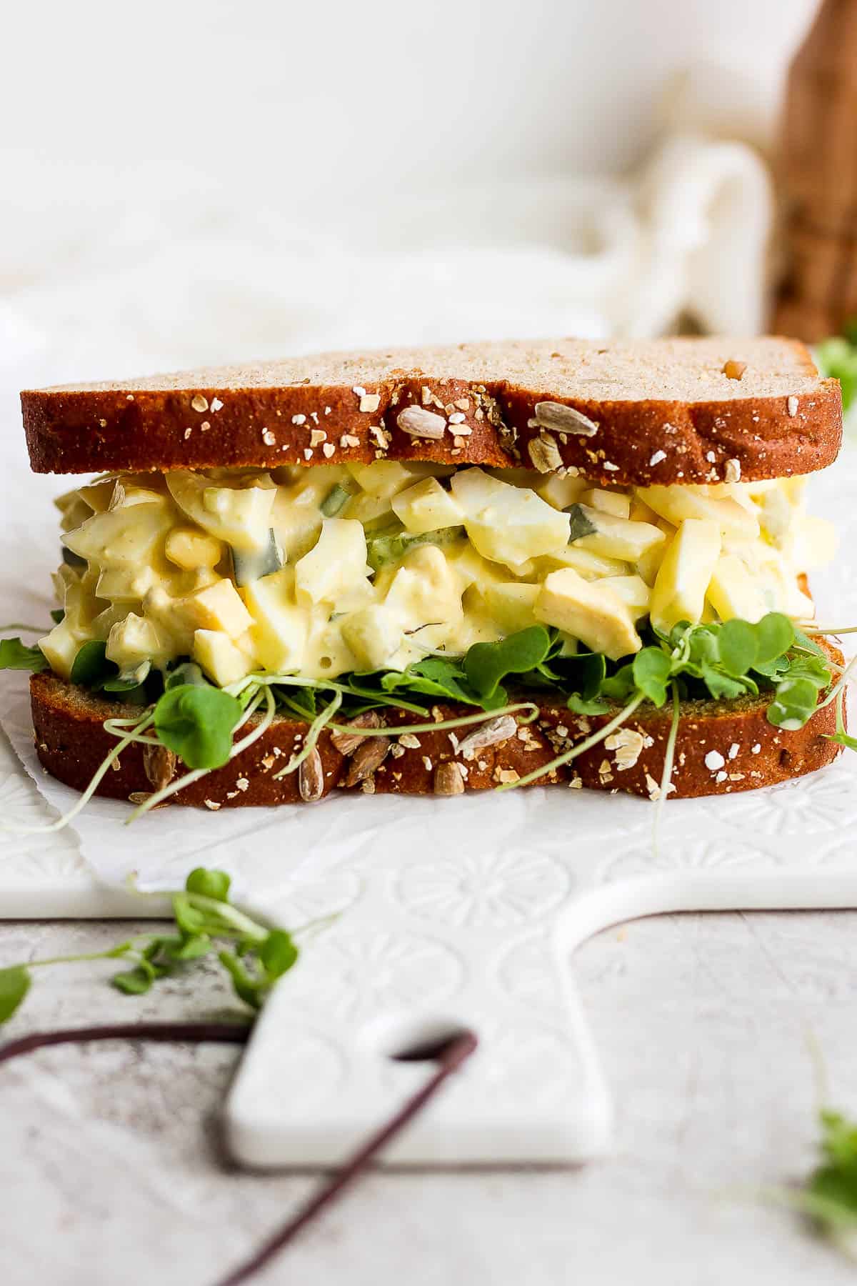 The best ever egg salad sandwich on a white board.