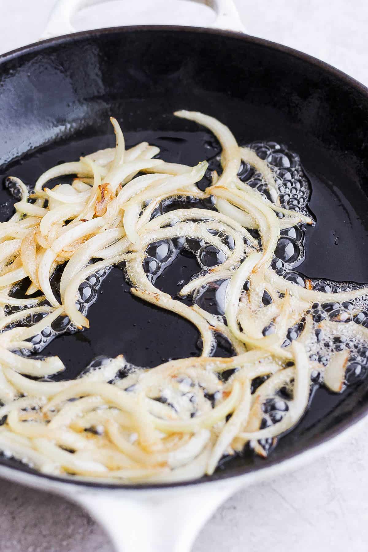Onion and garlic sautéing in a skillet.