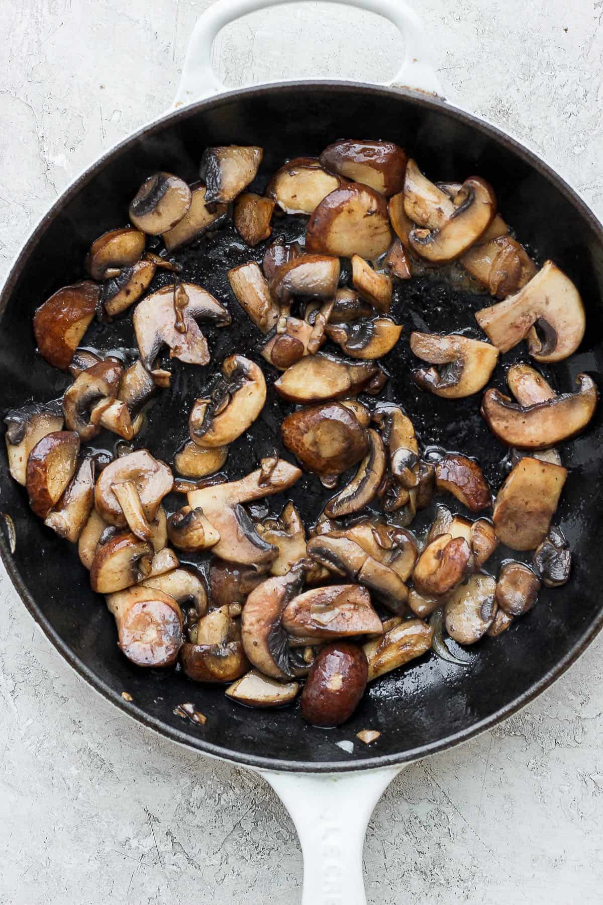 Baby bella mushrooms added to the skillet to soften.