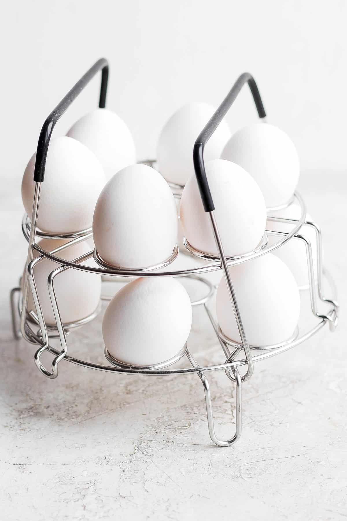 An instant pot egg rack filled with 12 eggs on a counter top.