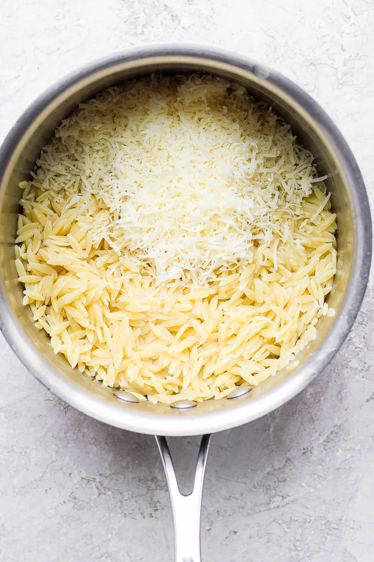 Cooked and drained orzo in the medium sauce pan with butter, parmesan, salt, pepper, and lemon zest.