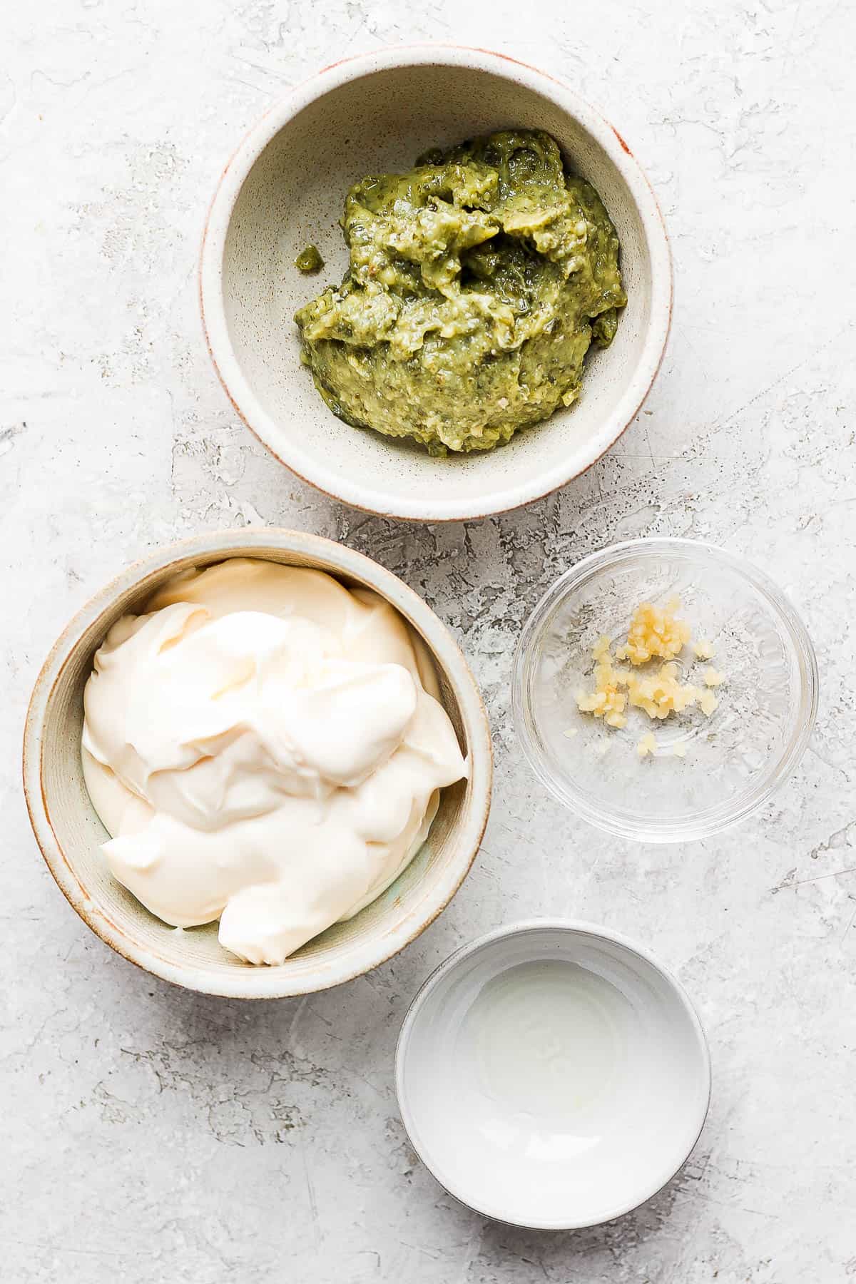 Pesto aioli ingredients in separate bowls.