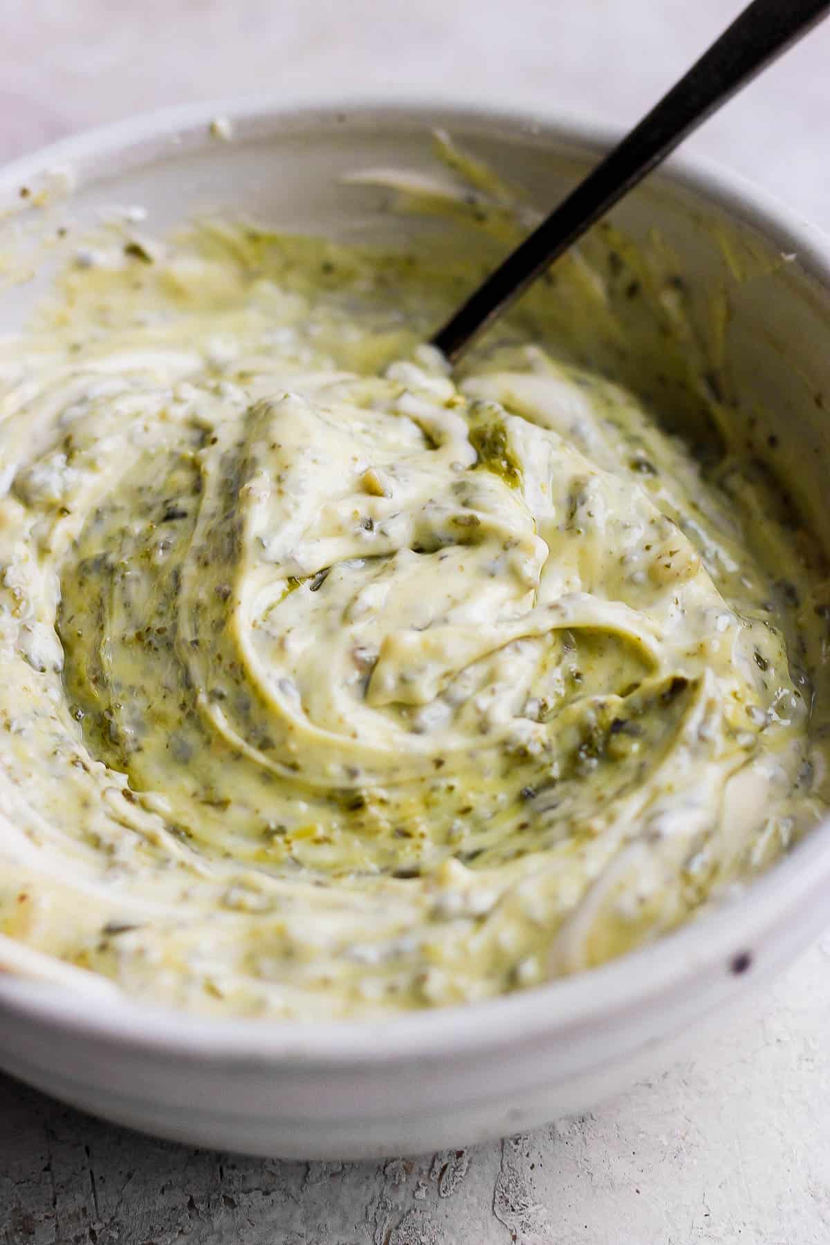 Pesto aioli all mixed together in a white bowl.