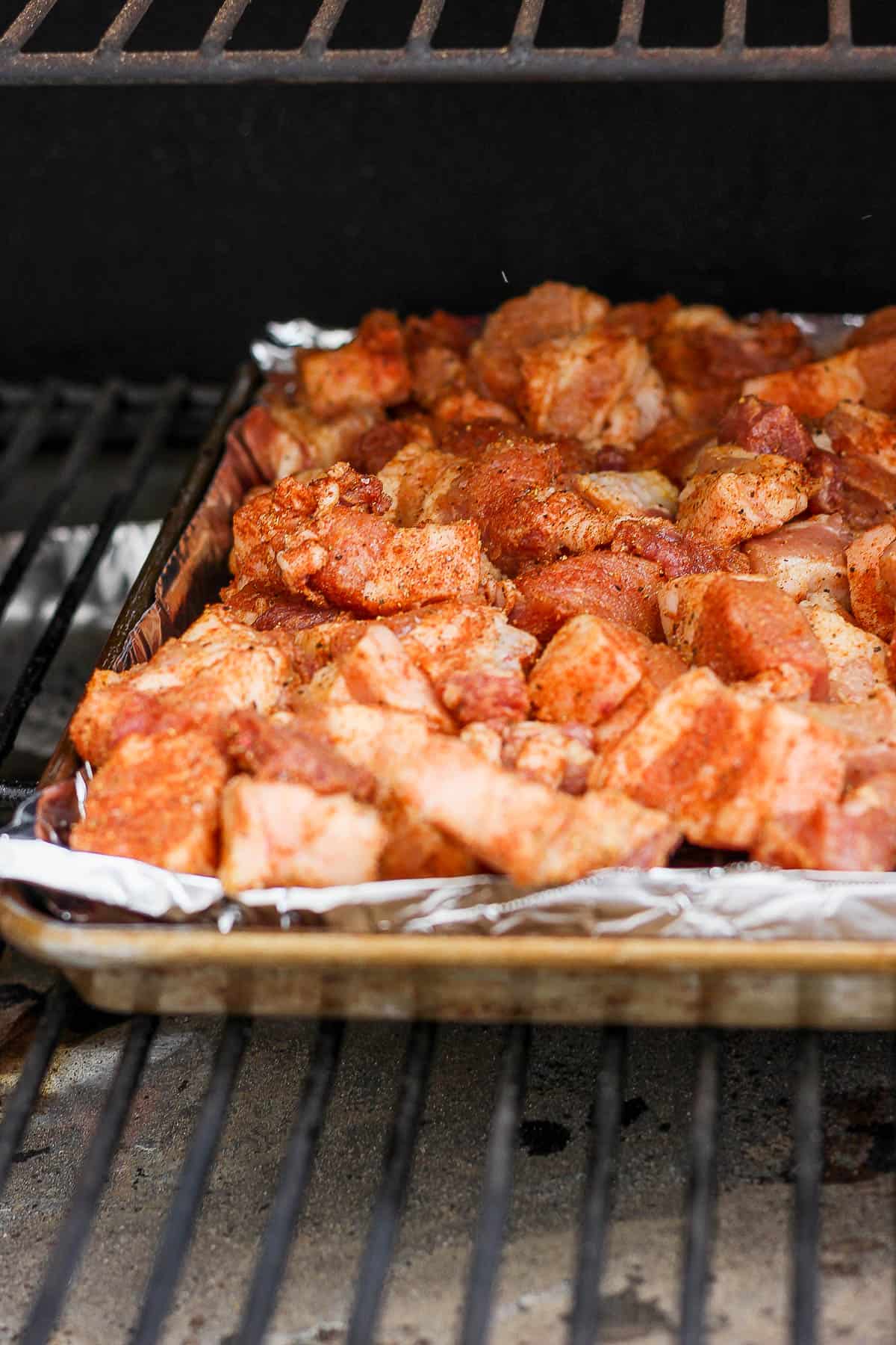 Baking sheet of pork belly on the smoker.