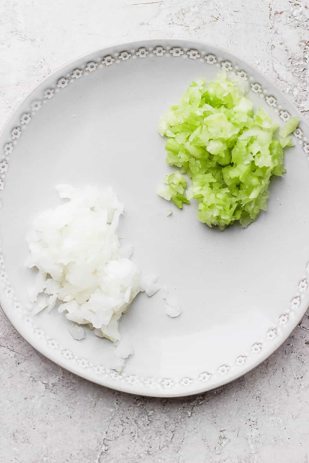 Minced celery and onion on a plate.
